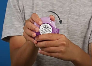 Diskus inhaler sliding the thumb grip back to the starting position