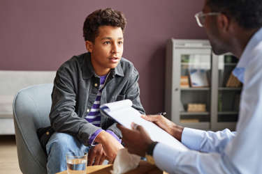 Teen sitting across from a health-care provider in an office
