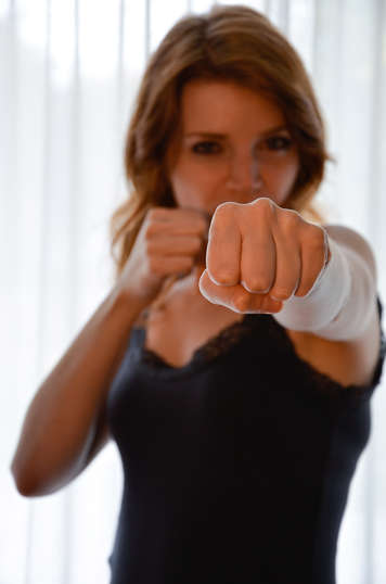 Young girl punching forward with left fist and holding right fist by her face