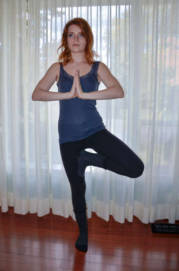 Young girl holding tree pose with foot placed above knee