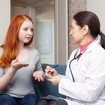Teen girl talking to doctor