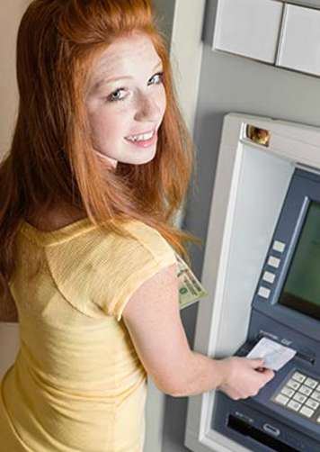 Teen girl using ATM