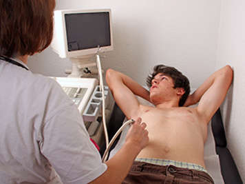 Teen boy having an ultrasound of abdomen