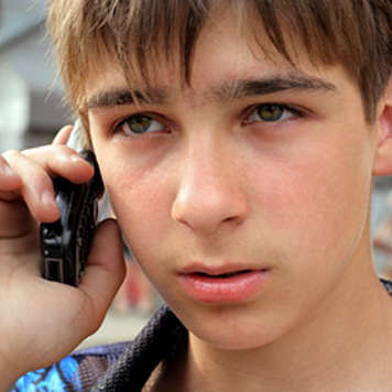 Teen boy holding cell phone to his ear