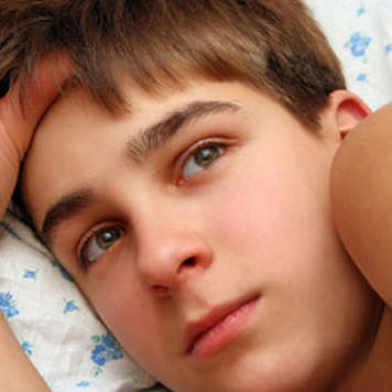 Teen boy lying in bed