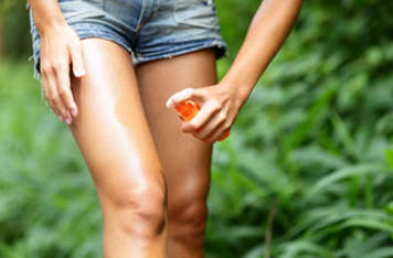Teen girl spraying insect repellent